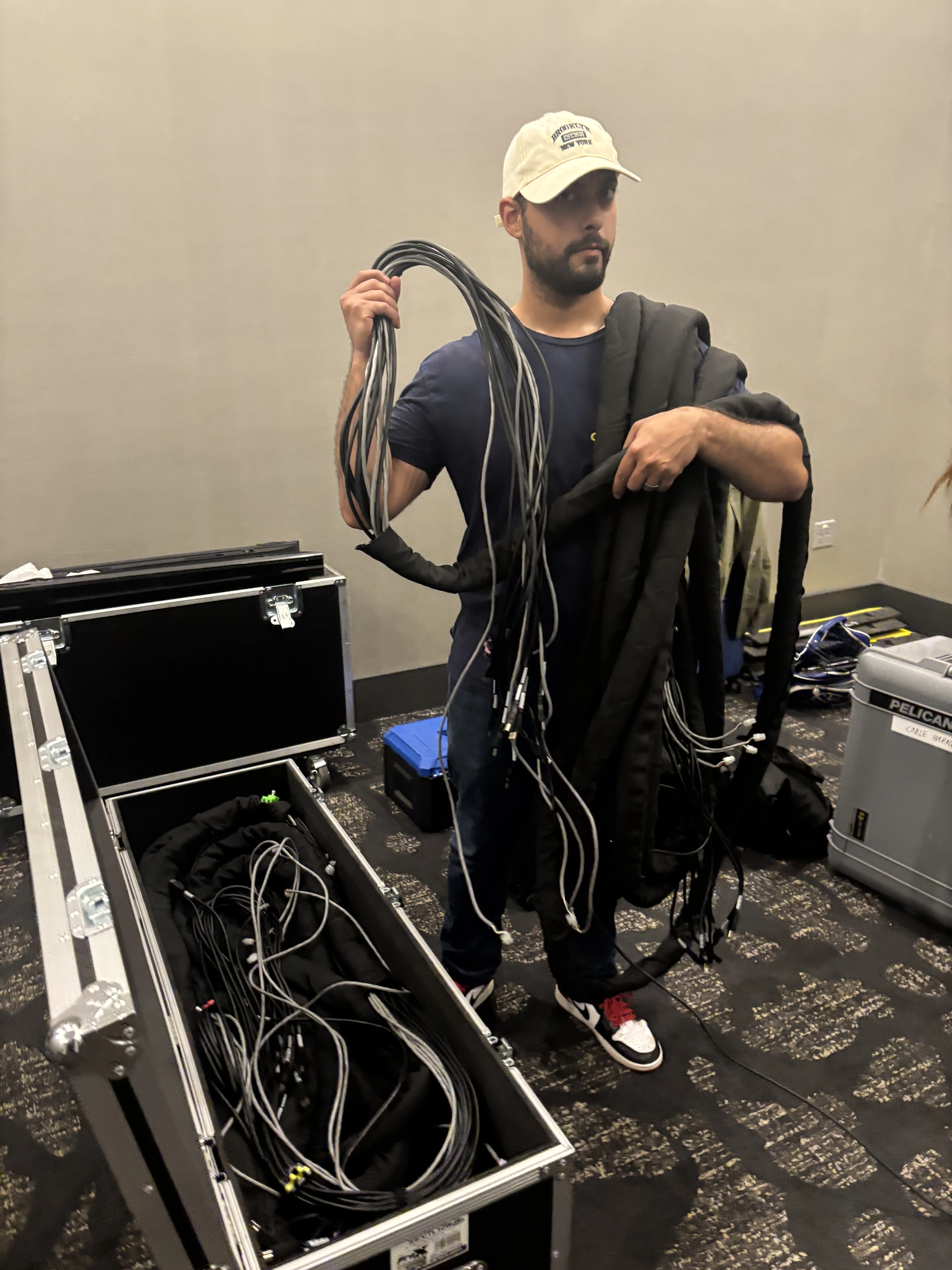 OpalOps crew member coiling event cabling and cords for load-in